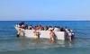 Moment tourists push boat packed with migrants away from shore after it attempted to land on beach on Greek paradise island