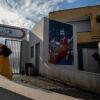 Locals pass a mural of Mohamed Salah at the entrance to the sports complex in his Egyptian home village of Nagrig