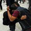 Osvaldo (R) caregiver of six-year-old US citizen Andy (L) hugs him as the boy prepares to fly to Guatemala to reunite with his recently deported father