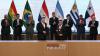 European Commissioner for Trade and Economic Security Maros Sefcovic (kleft) and Paraguay's Foreign Minister Rubén Ramírez Lezcano pose for pictures after signing documents as several regional leaders watch on during the signing ceremony of the trade…