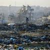 A Palestinian boy searches for recyclable material at a landfill against the backdrop of destroyed buildings in Khan Yunis, in the southern Gaza Strip on January 25, 2026. Since October 10, a fragile US-sponsored truce in Gaza has largely halted the…