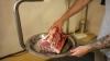 A worker weighs a cut of beef at a butcher shop in Rosario, Argentina, in 2025.