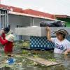 People carry belongings on a flooded street in Monteria, Colombia on February 9