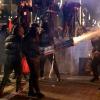 Protesters fire fireworks as they clash with anti-riot police in Tirana on February 10, 2026