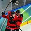 Nathan MacKinnon (L) celebrates scoring Canada's late winner over Finland at the 2026 Winter Olympics