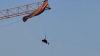 Terrifying moment paraglider is left dangling 200ft in the air for four HOURS after crashing into crane