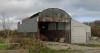Countryside Dutch barn in poor repair to be replaced by modern building