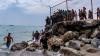 Migrant deaths rise to at least 57 after tens of thousands cross from Morocco into Spanish territory
