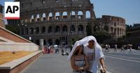 Tourists armed with water bottles brave Italy’s extreme heat