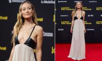 Olivia Wilde walks the red carpet in a plunging leather dress as she admits her new movie The Invite has made her 'become so much more romantic'