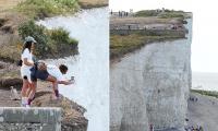 Selfie-loving tourists ignore warning signs as they hop over safety railings to pose perilously close to 500ft drop at Birling Gap