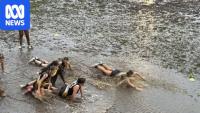 Deluge washes cars away and forces footy game to stop