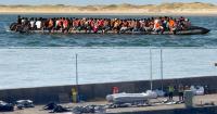 Huge migrant dinghy carrying 230 people pictured as French do nothing to stop boats