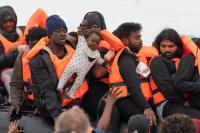 BABY IN PERIL Months-old baby seen being hauled onto Channel migrant mega-dinghy to UK – as French police stand by and do nothing