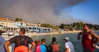 Tourists evacuated on boats as wildfire destroys popular Greek holiday spot