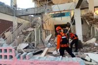World Associated Press Rescuers dig through rubble and landslides after Indonesia quake kills 47