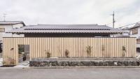 A compact Japanese house by Hitotomori is hidden behind a minimalist wooden fence