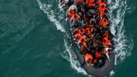 Shocking moment small boat migrants on French beach attack cops as they try to set sail to Britain