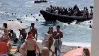 Moment shocked sunbathers confronted by migrants after smuggling boat lands on Spanish tourist beach