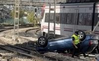 Car plunges from bridge onto Madrid train tracks, halting commuter trains