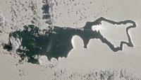 Rare sunlight trick transforms Pacific island into a giant silver 'magnifying glass' — Earth from space