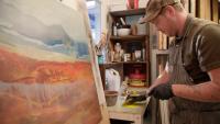 With layered pigments, a painter builds imagined mountains