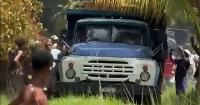 A truck loaded with oil is being robbed in Havana, witnessed helplessly by the police