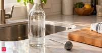 Use undiluted 5% white vinegar at 130°F for 1 minute; Colorado State Extension says it can reduce Listeria, E. coli, and Salmonella by over 99.999% on hard surfaces