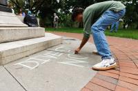 Protestors chalk on campus against Ohio State’s partnership with Anduril and the university chalk ban