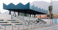 ribbed lime-green gateway and blue solar canopy reform municipal sports center in spain