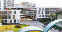 elliptical classroom volumes and colorful louvers shape courtyard kindergarten in hanoi
