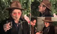 Johnny Depp BITES leaves off plant backdrop as he raises a toast in bizarre display at Las Vegas booze festival