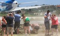 Rise of dangerous 'jet blast' trend: Thrill-seeking tourists who stand under 'intense' stream of air from plane's engines warned they risk 'serious injury'