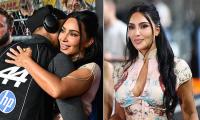 Kim Kardashian walks the Singapore Grand Prix paddock in floral corset dress as she shares a good luck hug and kiss with Lewis Hamilton