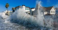 Dual tropical storms hit both U.S. coasts with floods and outages