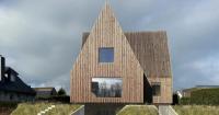 four pitched-roof volumes build timber-clad coastal house in belgium