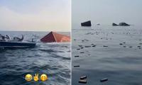 Iranians go fishing for iPhones and French perfume floating in the Strait of Hormuz after container ship is blown up by mine and sinks