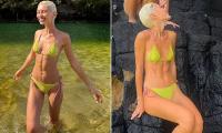 Iris Law shows off her svelte physique in a lime green bikini as she frolics in the sea in Hawaii  - after hitting back at nepo baby claims